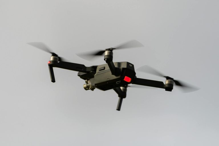 A sleek black quadcopter drone captured in mid-flight, demonstrating modern technology.
