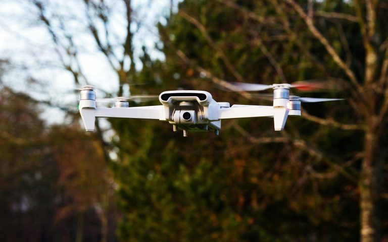 Close-up of a drone hovering in a natural outdoor setting, showcasing modern technology.