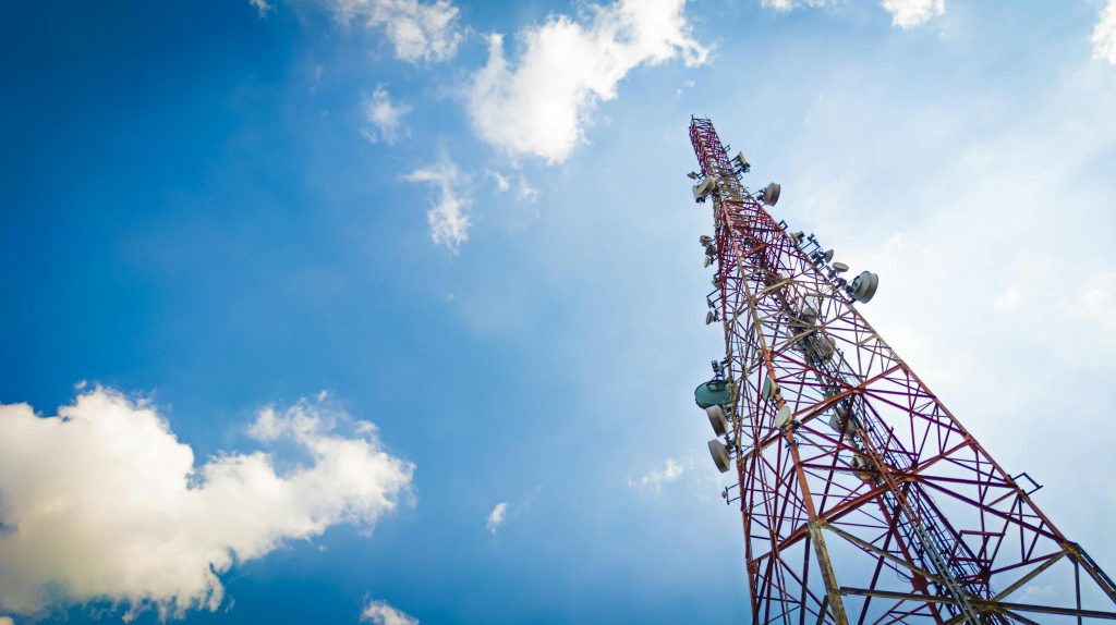 View of a tall telecom tower set against a clear blue sky in Depok, Indonesia.